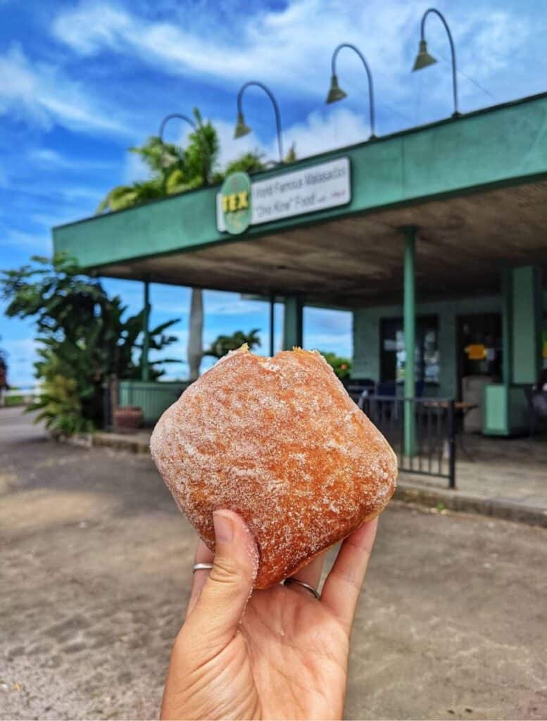 my hand holding a tex drive in malasada in front of their building