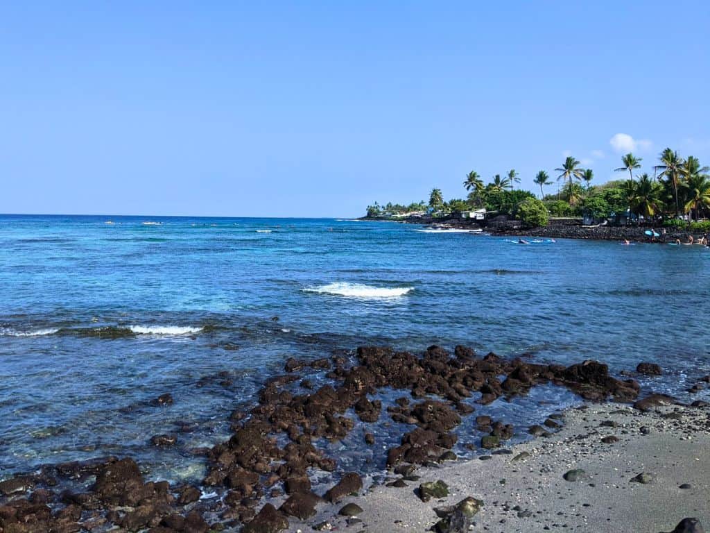 a view of Kahalu’u Beach from a rocky shoreline
