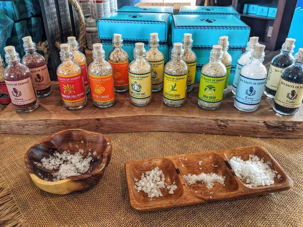 row of bottles of Kona Sea Salt Farm flavors with bowls of salt grains