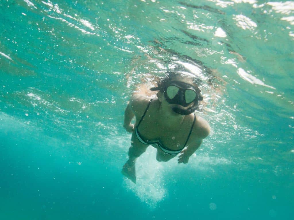 underwater view of woman snorkeling in a black mask