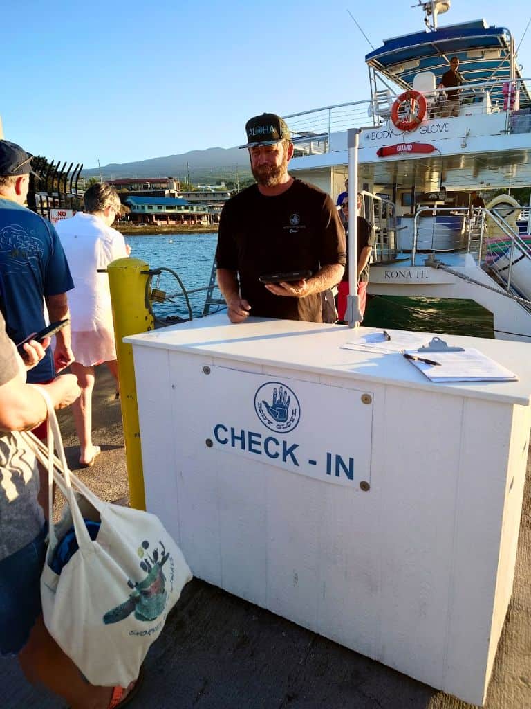 check in desk for body glove on the pier. man with ipad checking in. body glove in background