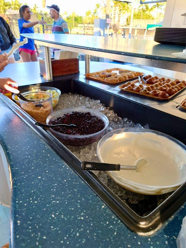 self serve breakfast bar on body glove with big bowls of granola, fruit, and yogurt