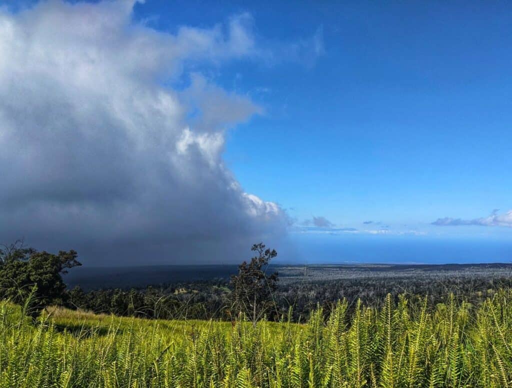 View of the Ka'u district from the Pali o Ka’eo Trail with a dark storm cloud looming