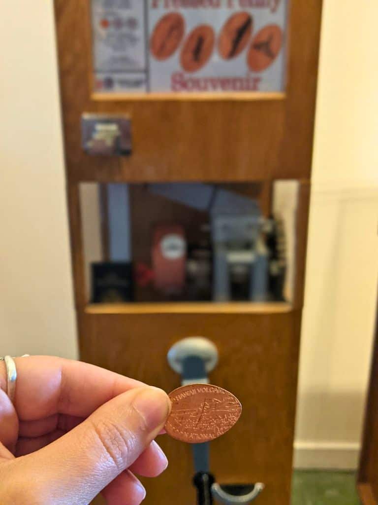 my hand holding a penny that i pressed at Volcano House Hotel