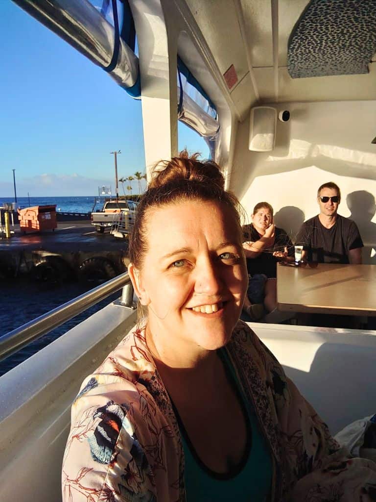selfie of me at my booth seat with other passengers sitting in the booth behind me. we are still in dock