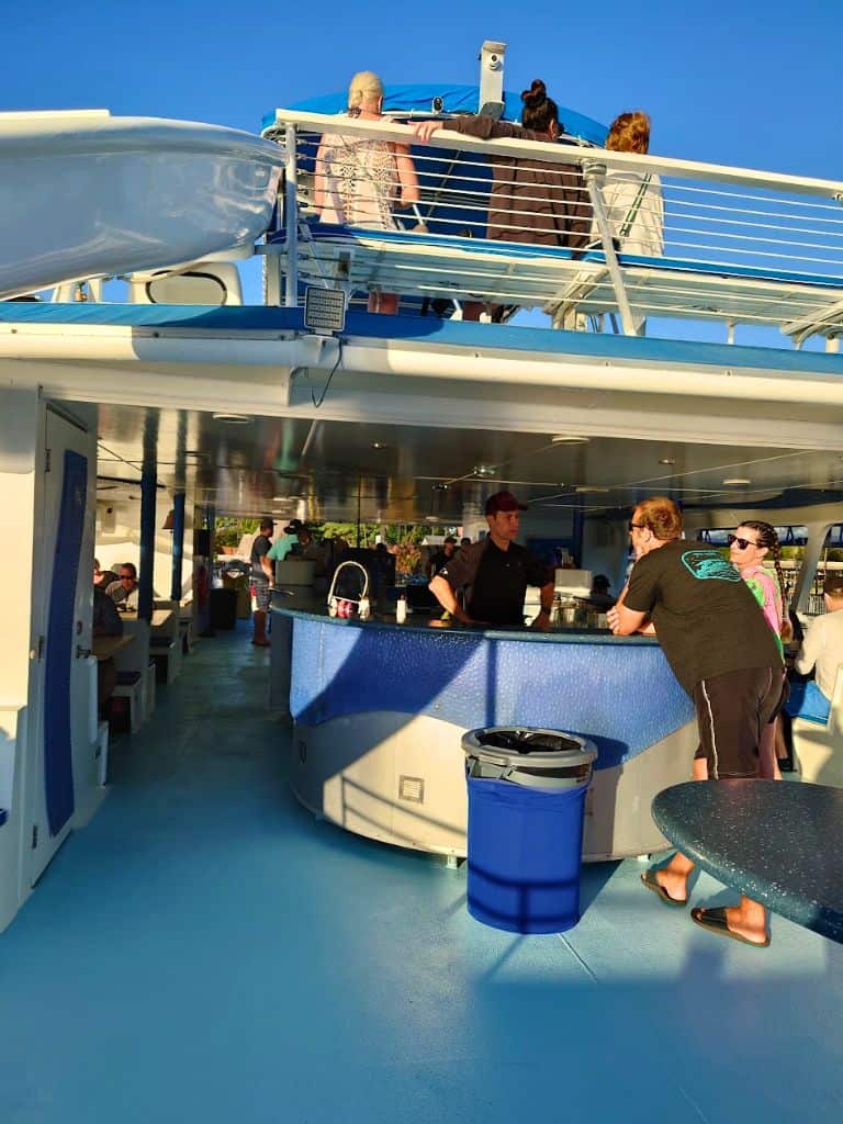 Drinks bar on the first level with people sitting on benches on the top deck