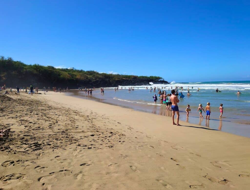 people enjoying hapuna beach on a sunny day
