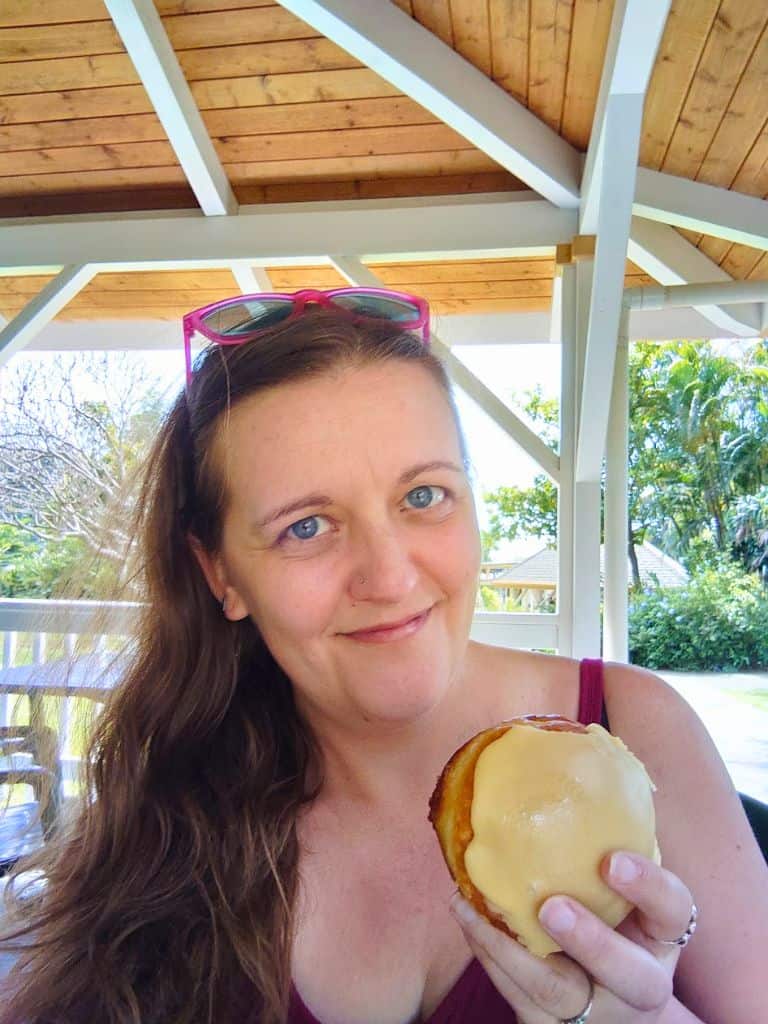 Me with a lilikoi malasada from Punalu'u Bake Shop under a gazebo