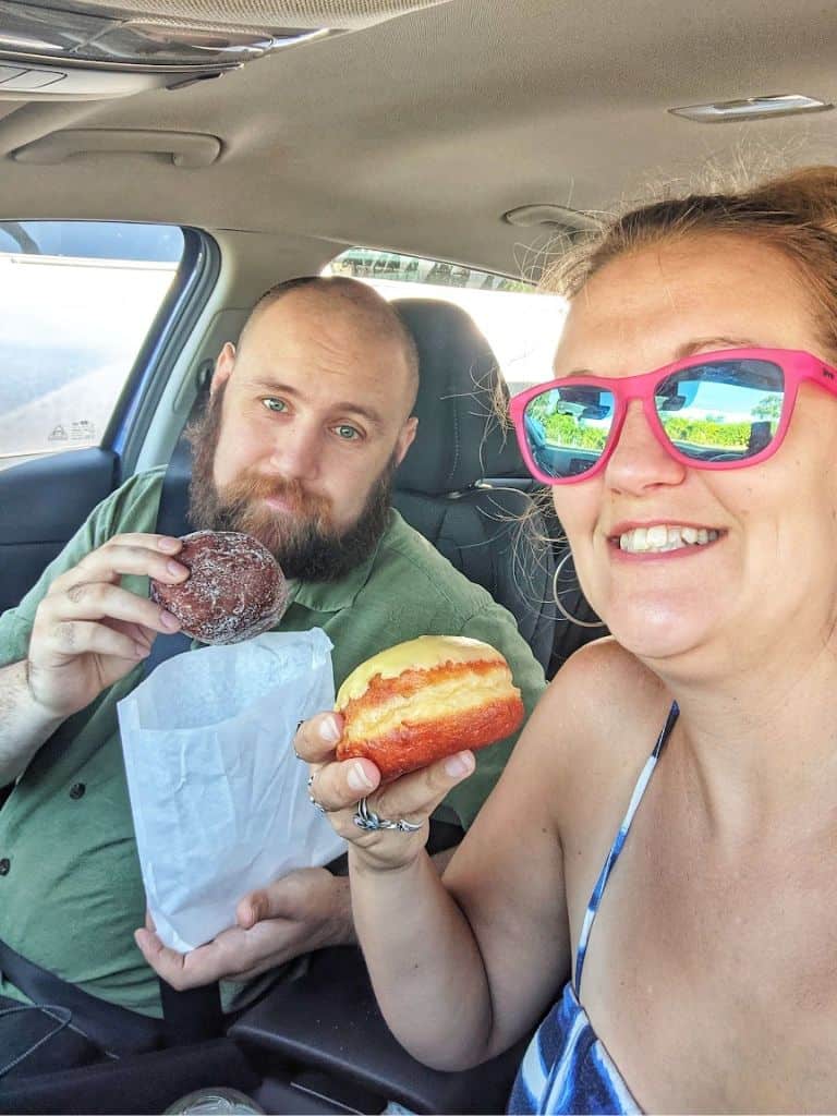 Michael with a taro malasada and me with a lilikoi malasada from Punalu'u Bake Shop