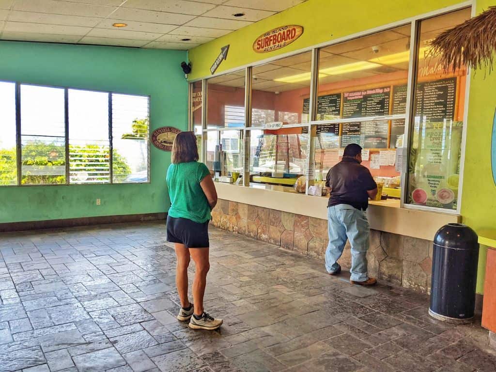 people standing in line to order at the glass window at tex drive in. colorful walls