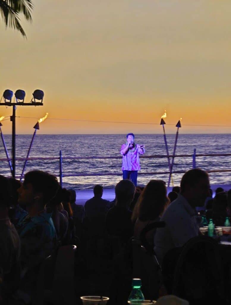MC announcing special occasions in the audience on stage with ocean in background