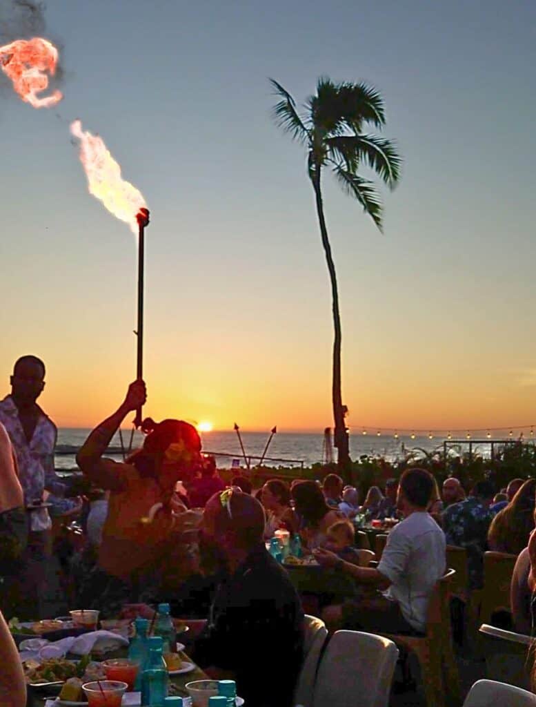 Tiki torch lighter running through the tables at sunset