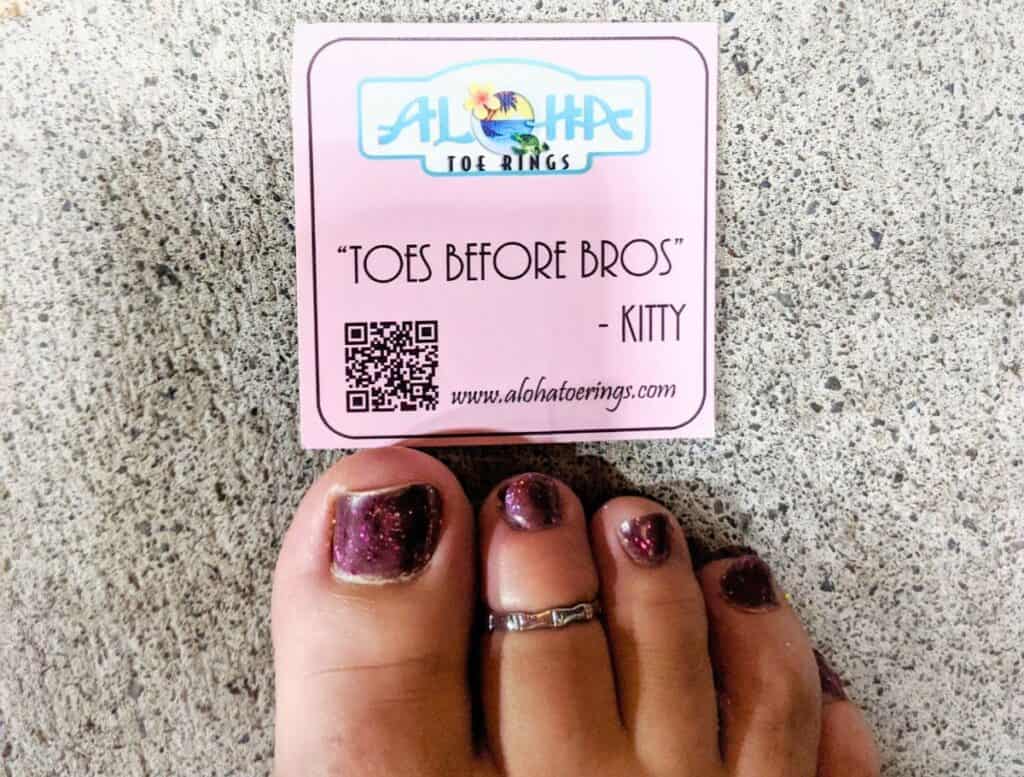 My bamboo toe ring from Aloha Toe Rings on my toes painted purple with their business card above toes