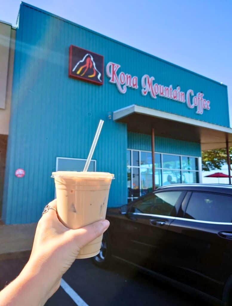 my hand holding a cup of Iced latte from Kona Mountain Coffee