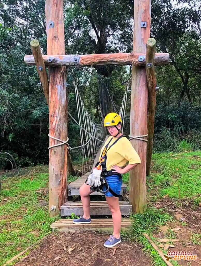 Me wearing zipline harness and yellow helmet doing my pre-tour pose in front of our first bridge to cross