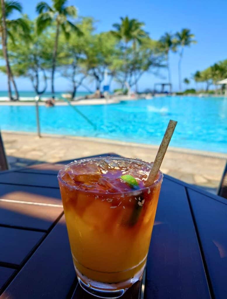 Naupaka Beach Grill mai tai with coconut rim and pool in background
