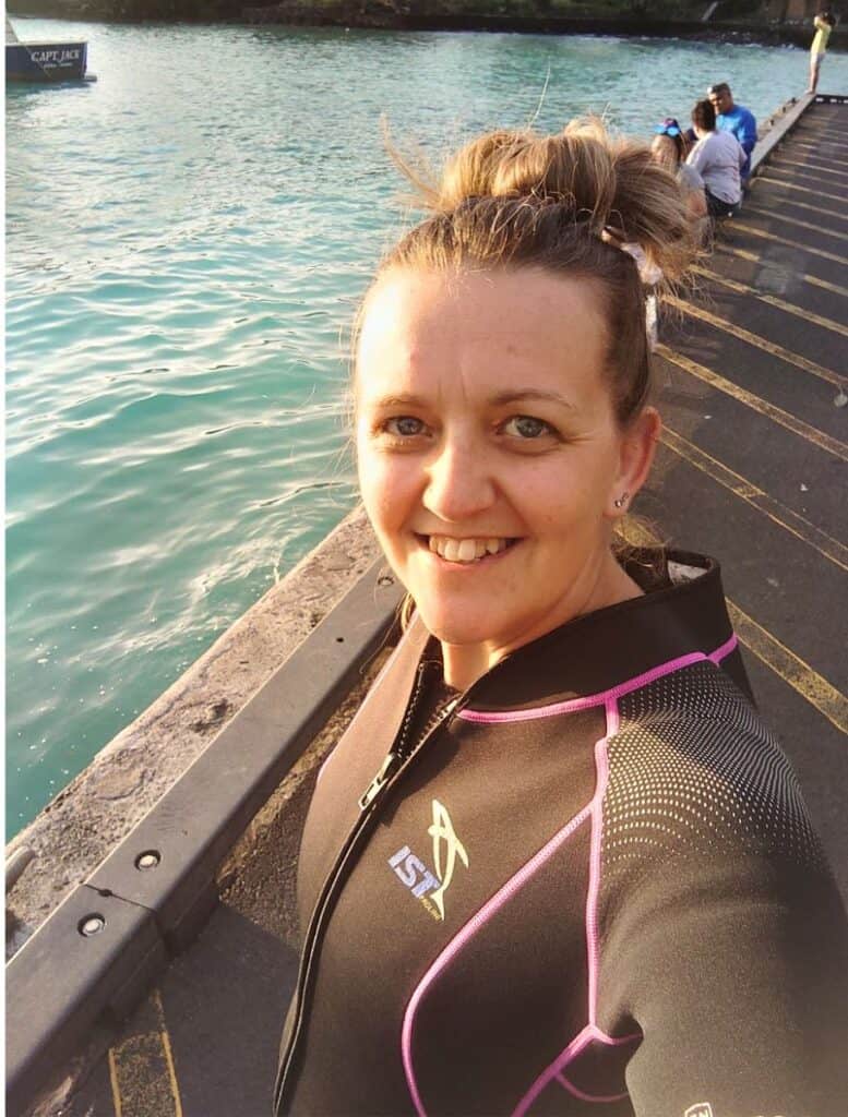 selfie of Me sporting my wetsuit, black with pink trim, on the pier