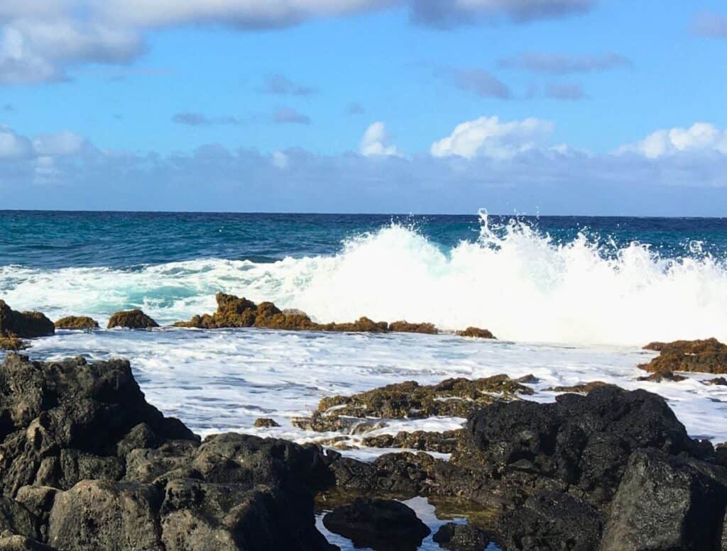 waves crashing against lava rock at secret tidepool