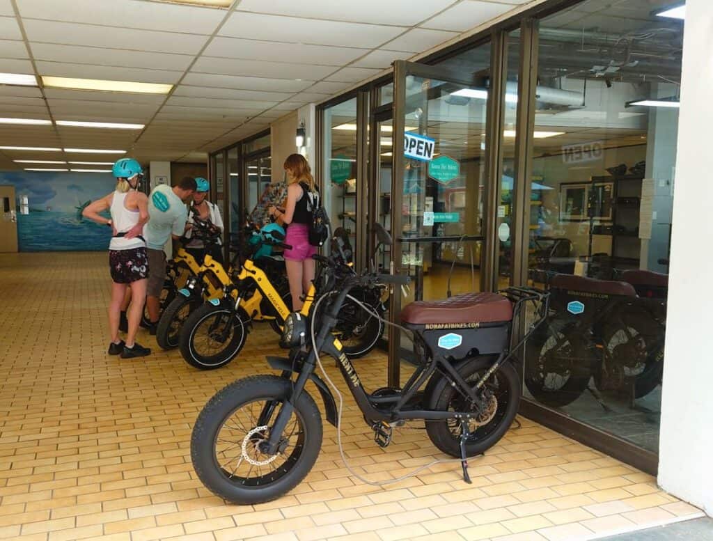 Kona Fat Bikes rental with people getting their bikes and wearing helmets
