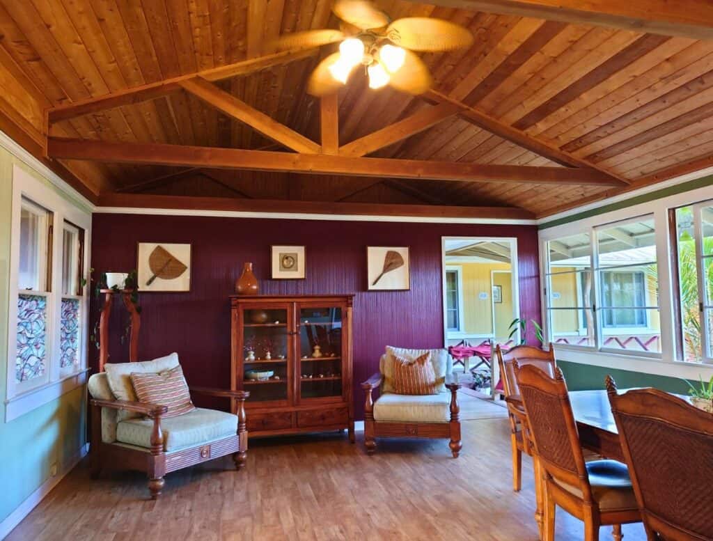 Plantation-style lobby of to Kohala Village Inn with sitting room chairs and dining table