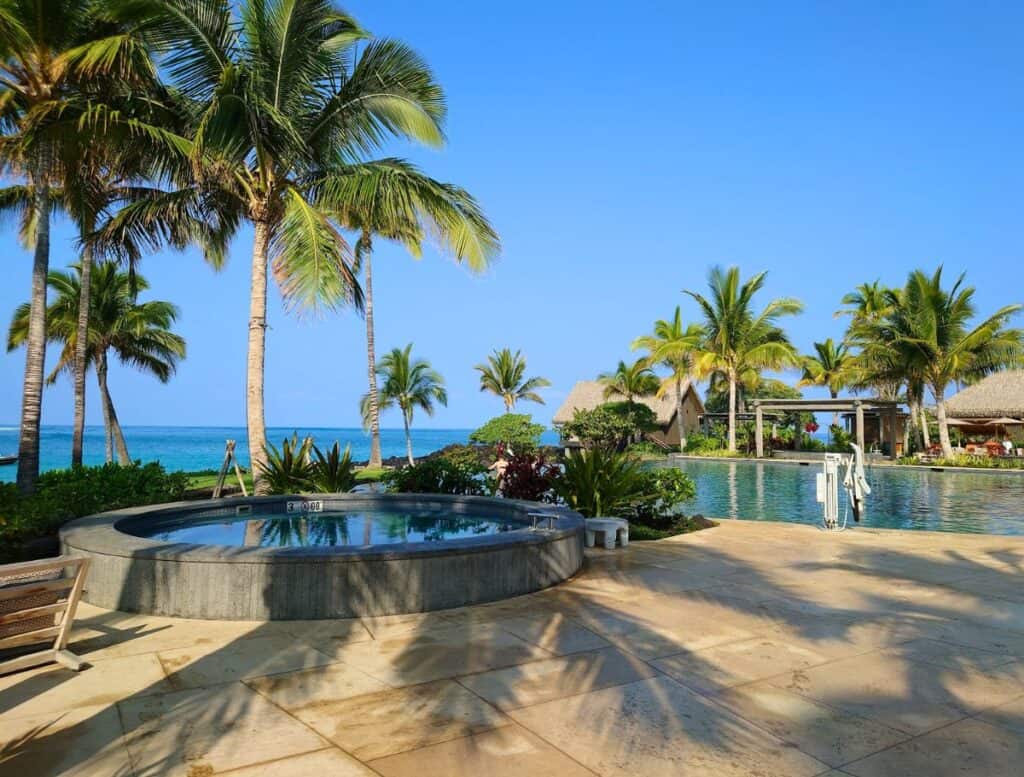 a pool with palm trees and a building on the side