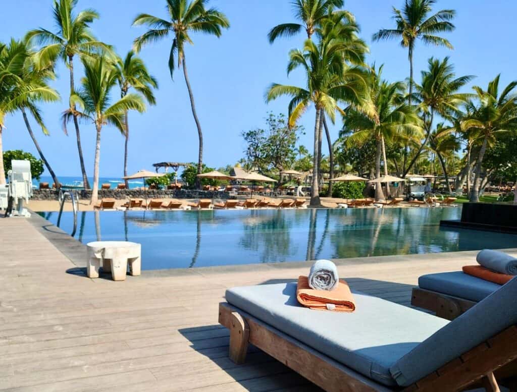infinity pool with lounge chairs and palm trees