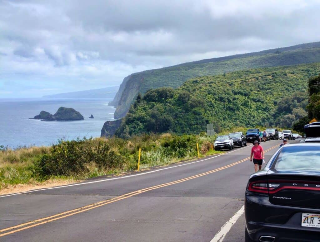 View of Pololu Valley from the road with cars parked on the shoulders, one of the stops in the Shaka Guide