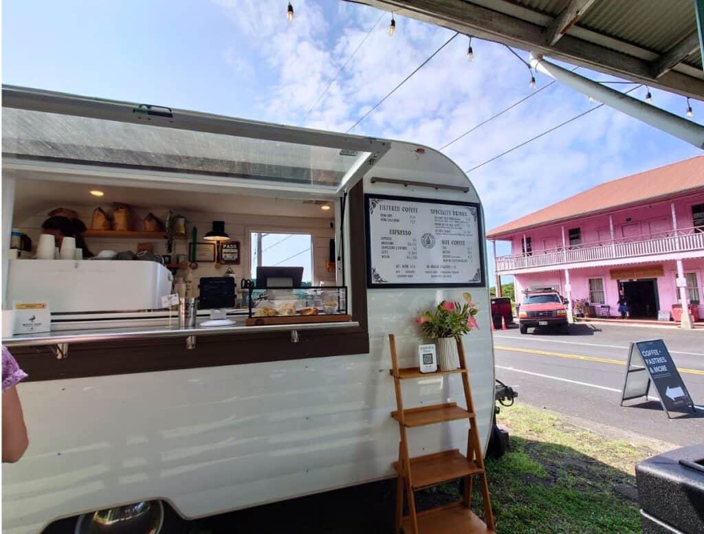 white nene trailer food truck with pink building in background