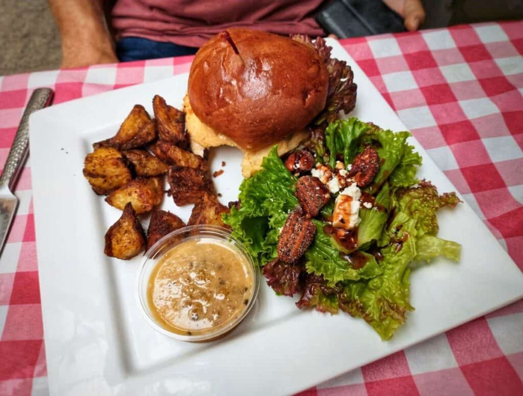 Vanilla lunch plate at Hawaiian Vanilla Co of potatoes, salad, and burger on red/white checkered tablecloth