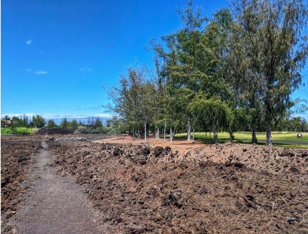 Waikoloa Petroglyph Reserve gravel trail through lava rock field and golf cart trail to the side