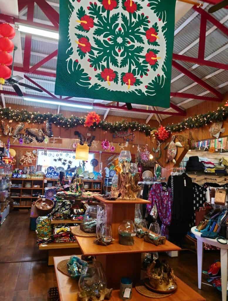 inside One of the boutique stores in downtown Honoka'a with clothes, glasswear and other hawaiian knickknacks including a hawaiian quilt hanging from ceiling