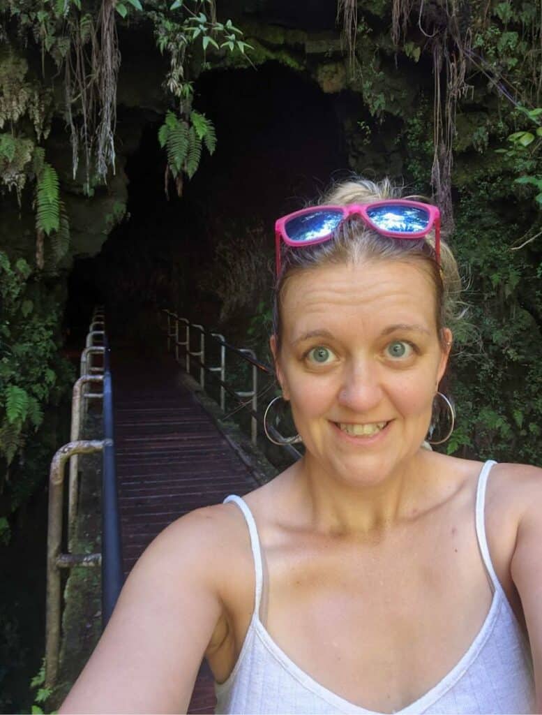 me with pink sunglasses on my head, standing before the entrance to thurston lava tube