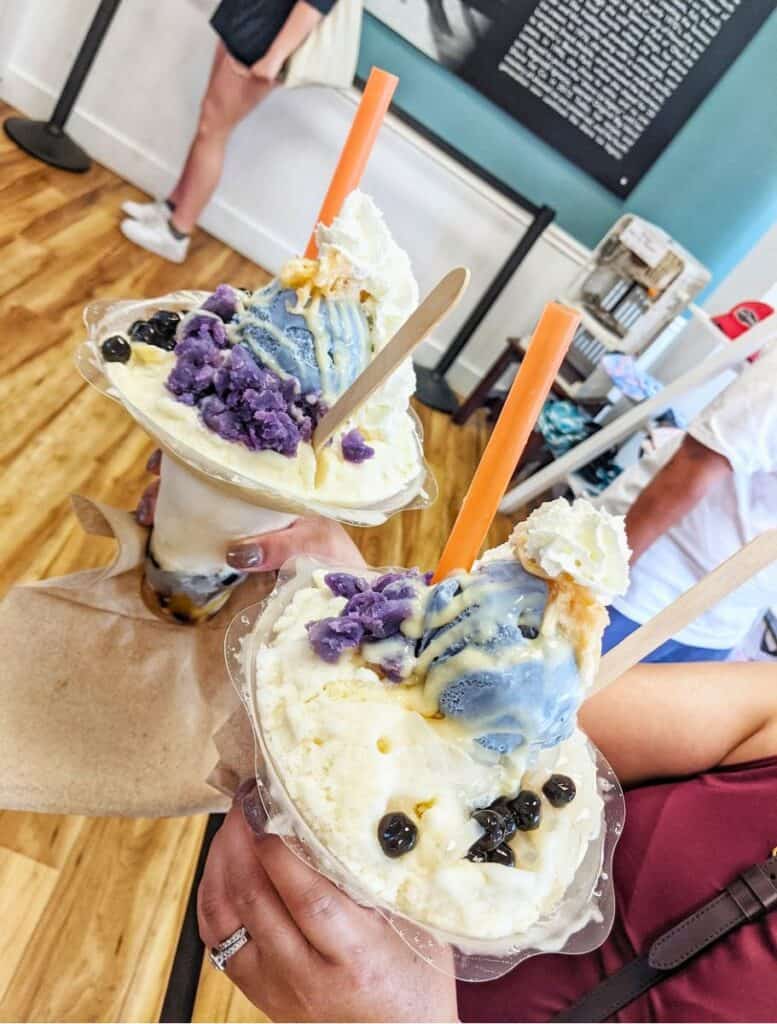 two giant gawdy bowls/cups of obisic shave ice with purple ube and boba